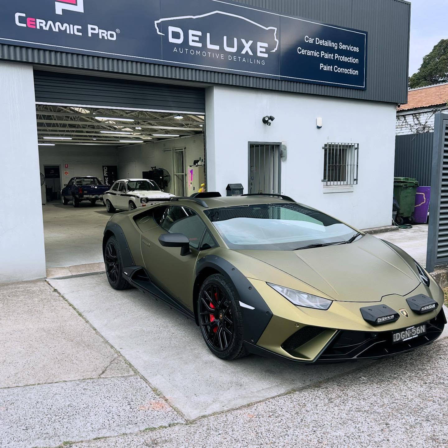 Professional detailer washing luxury vehicle, showcasing ease of maintenance with ceramic coating