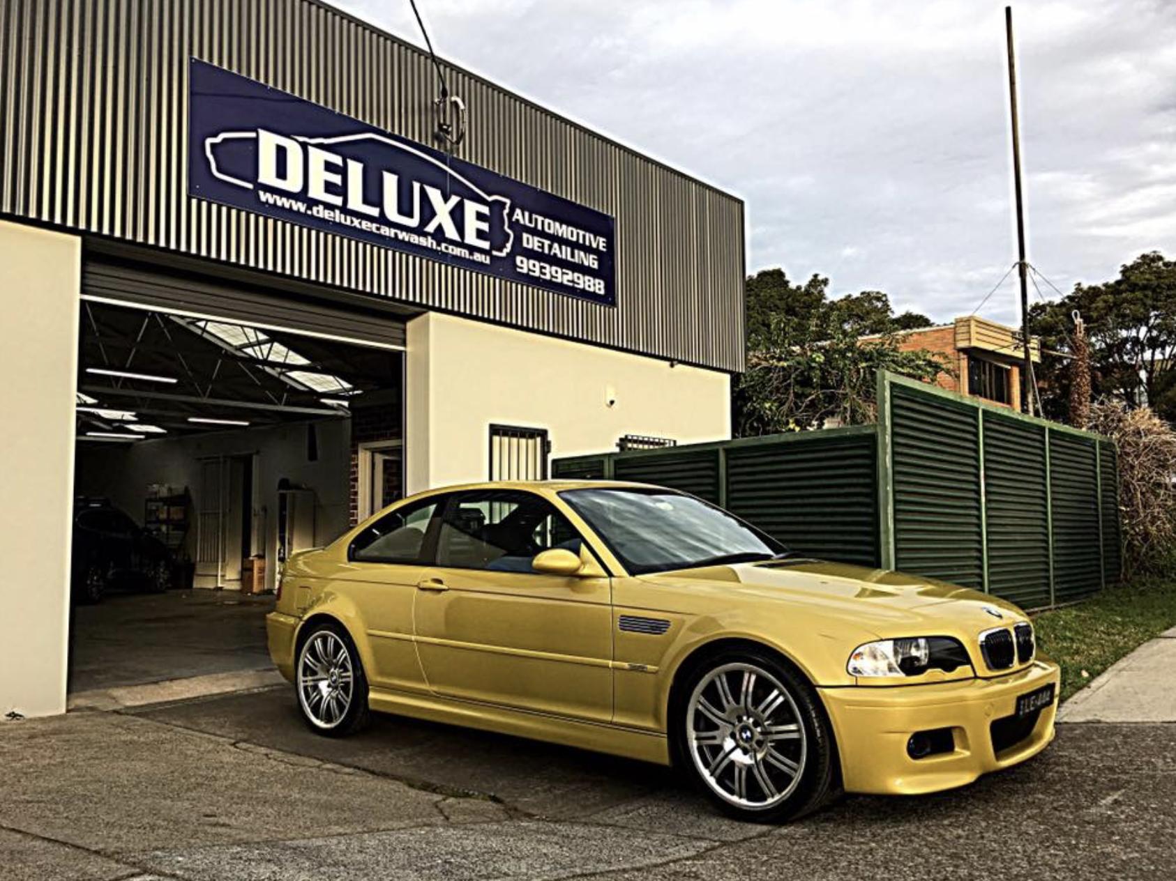 Person washing vehicle with ceramic coating, demonstrating maintenance ease